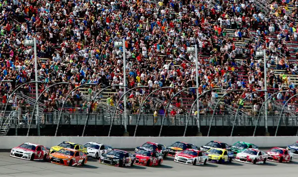 Carl Edwards, driver of the #19 ARRIS Toyota, and Kevin Harvick, driver of the #4 Budweiser/Jimmy John's Chevrolet, lead the field to a restart during the NASCAR Sprint Cup Series Quicken Loans 400 at Michigan International Speedway on June 14, 2015 in Brooklyn, Michigan.