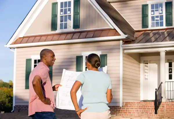 couple standing outside house