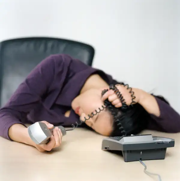 person asleep with phone on desk