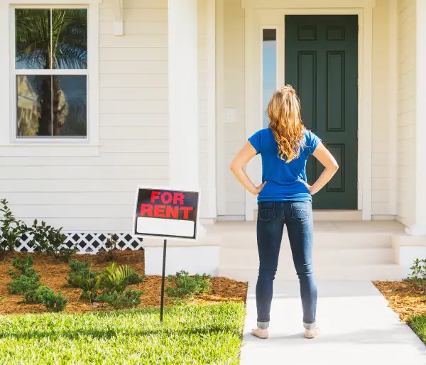 Millennial in front of house for rent