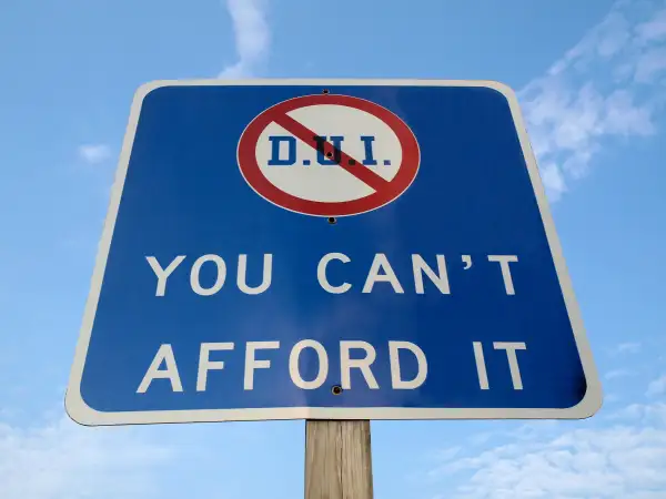 Highway sign with DUI crossed out saying  You Can't Afford It