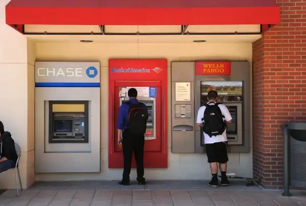 college students with backpacks at atm machines