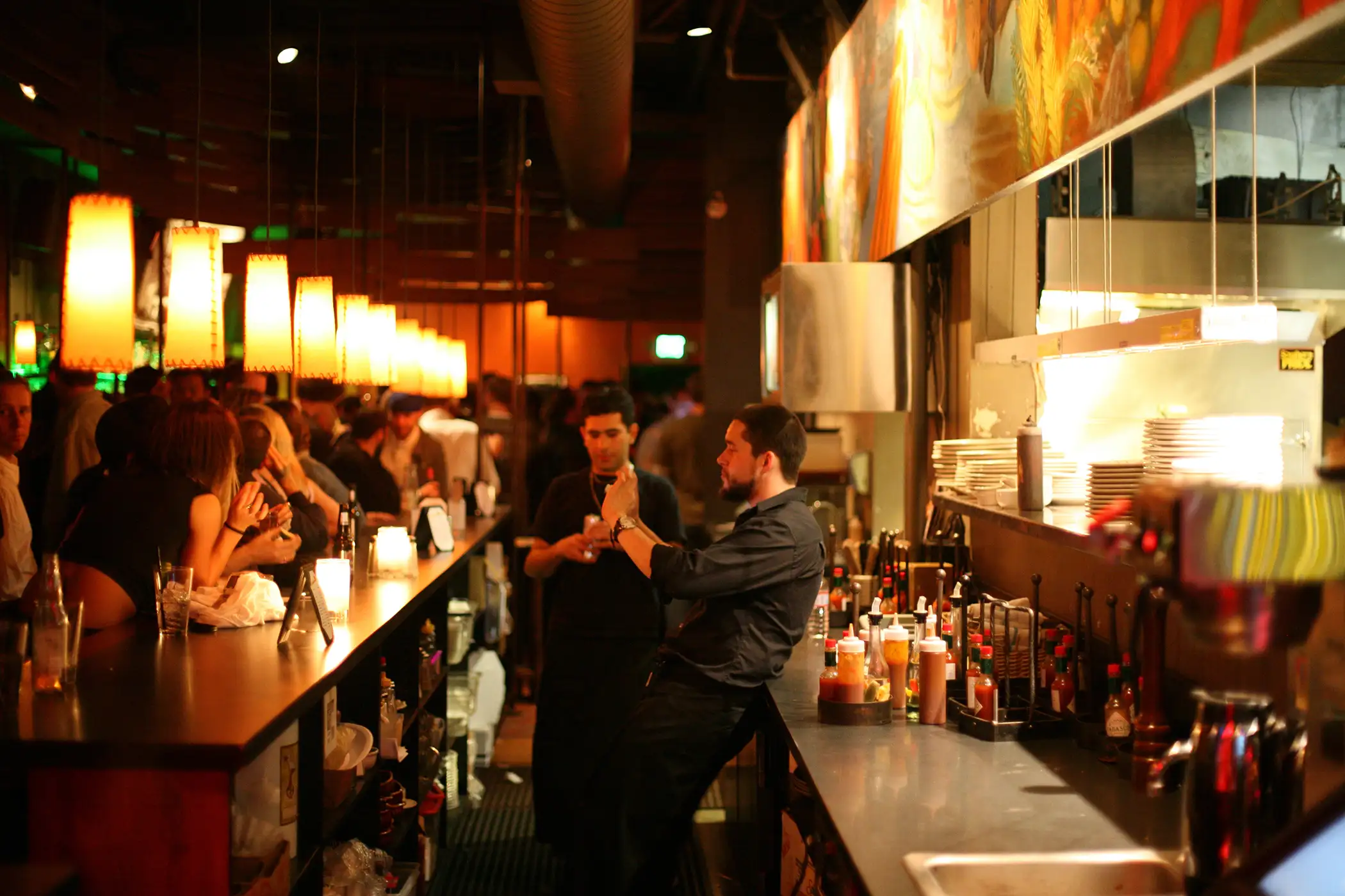Bartender taking photograph of patrons in bar at Belltown, Seattle, Washington