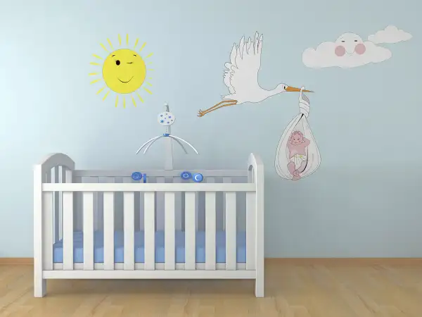 nursery with decal of stork carrying baby on wall