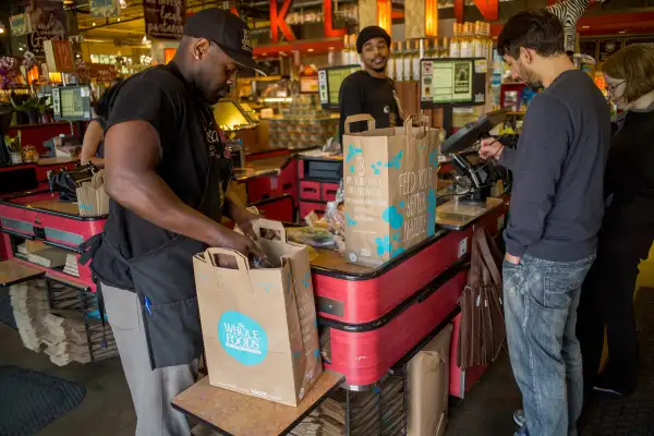 An employee bags groceries for customers at a Whole Foods Market Inc. store in Oakland, California, U.S., on Wednesday, May 6, 2015.