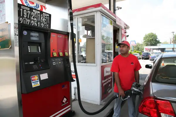 A gas attendant at a 19 Petroleum gas station pumps gas on August 25, 2015 in Woodbridge, New Jersey. Some places in New Jersey are seeing prices under two dollars as the price of gasoline continues to fall.