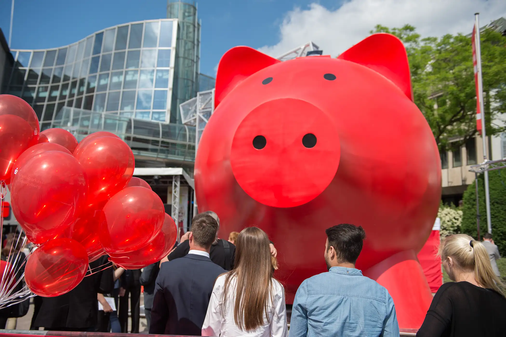 Spectators look on as the 'world's largest piggy bank' is being unveiled during a ceremony at Schillerplatz in Ludwigsburg, Germany, 18 May 2015. The two-story tall piggy bank was designed to motivate people to save money.