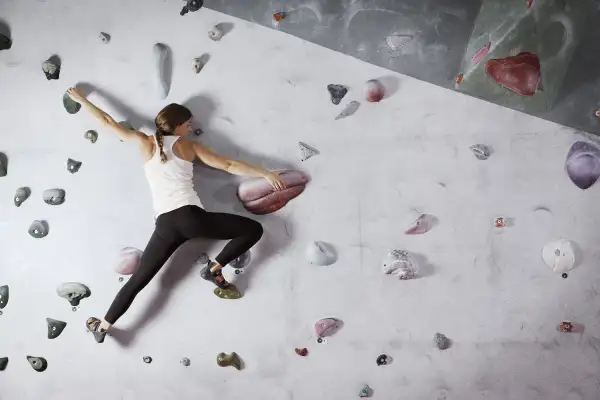 woman on rock climbing wall at gym