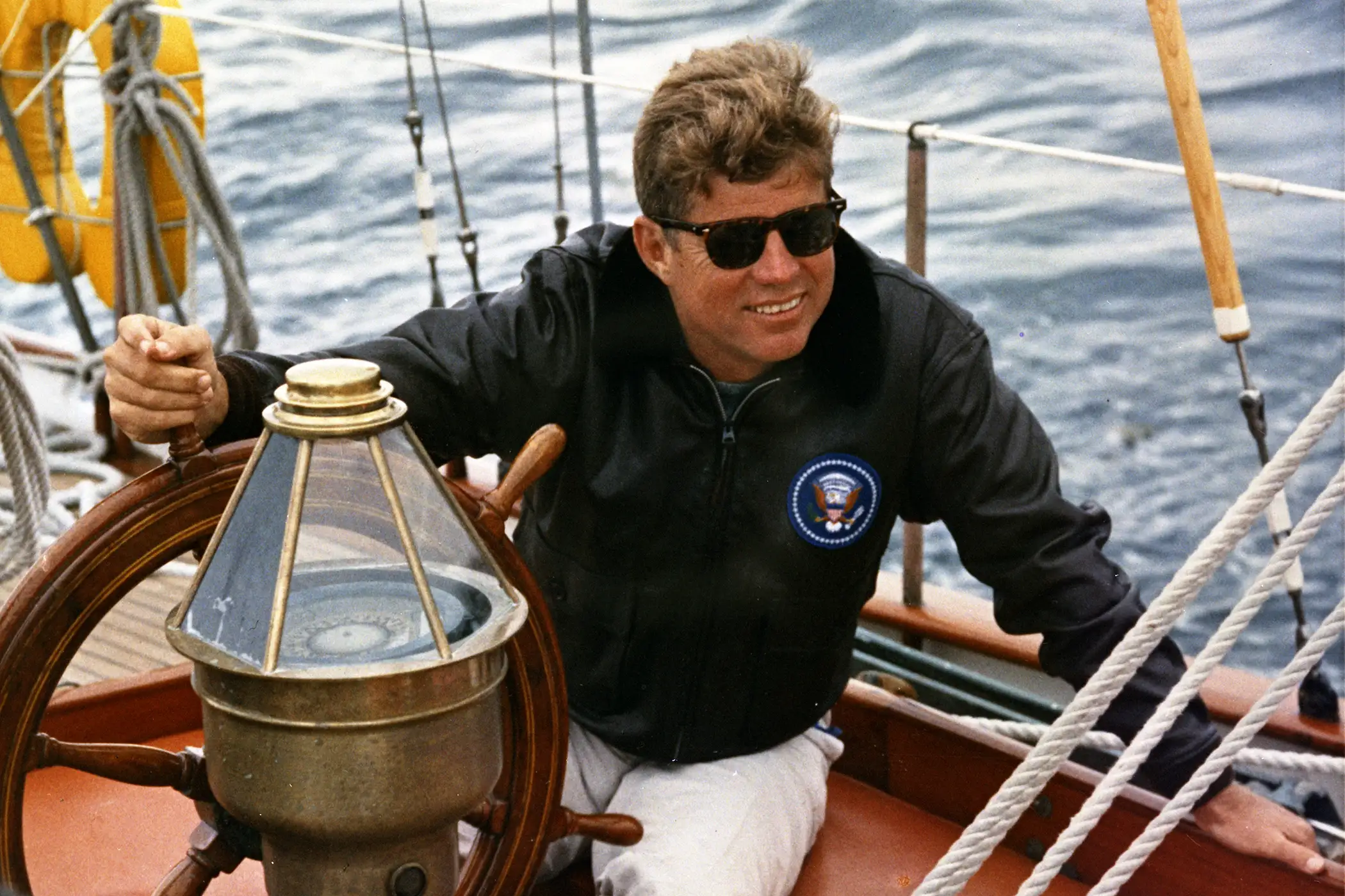 President Kennedy sails aboard the Manitou off the coast of Maine, 12 August 1962.