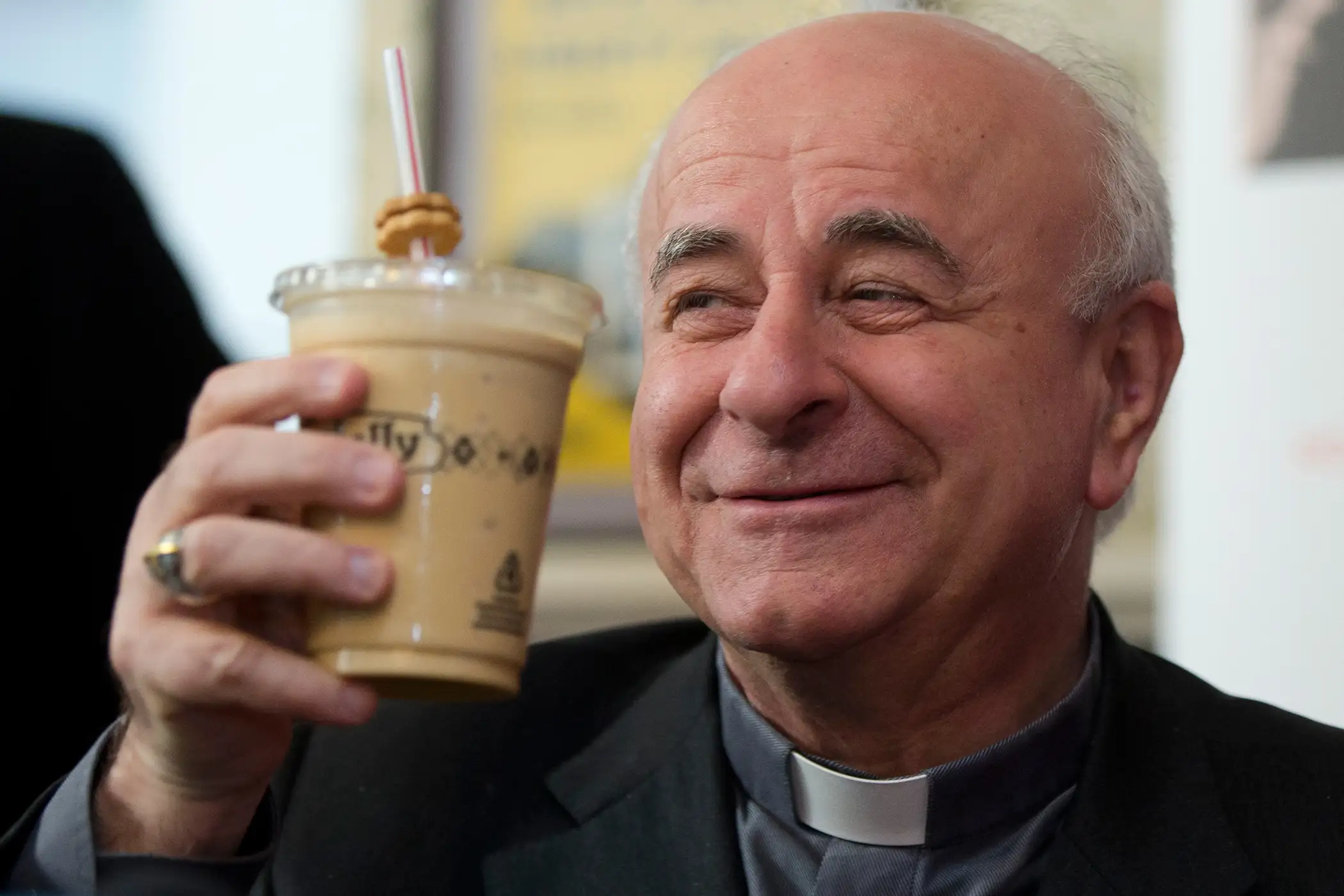 Archbishop Vincenzo Paglia lifts a milkshake during a news conference to pick a milkshake for the upcoming World Meeting of Families, Monday, March 9, 2015, at a Potbelly Sandwich Shop in Philadelphia.