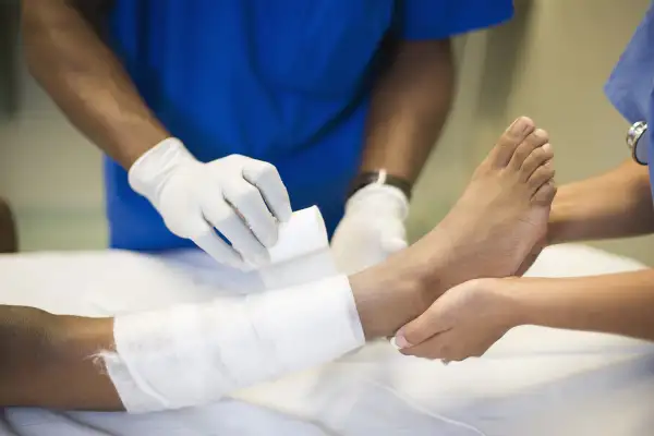 Doctors treating girl's leg with bandages