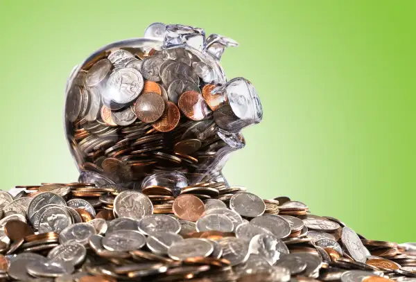 filled piggy bank on mountain of coins