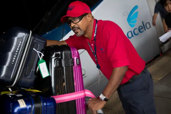 An Amtrak red cap baggage handler pushes a cart next to an Amtrak Acela passenger train at Union Station in Washington, D.C., U.S., on September 3, 2015.