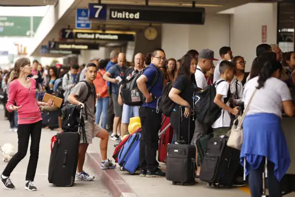 Passengers wait in long lines at the United Airlines terminal at LAX in the morning after a nation-wide flight stoppage July 8, 2015 in Los Angeles, California.