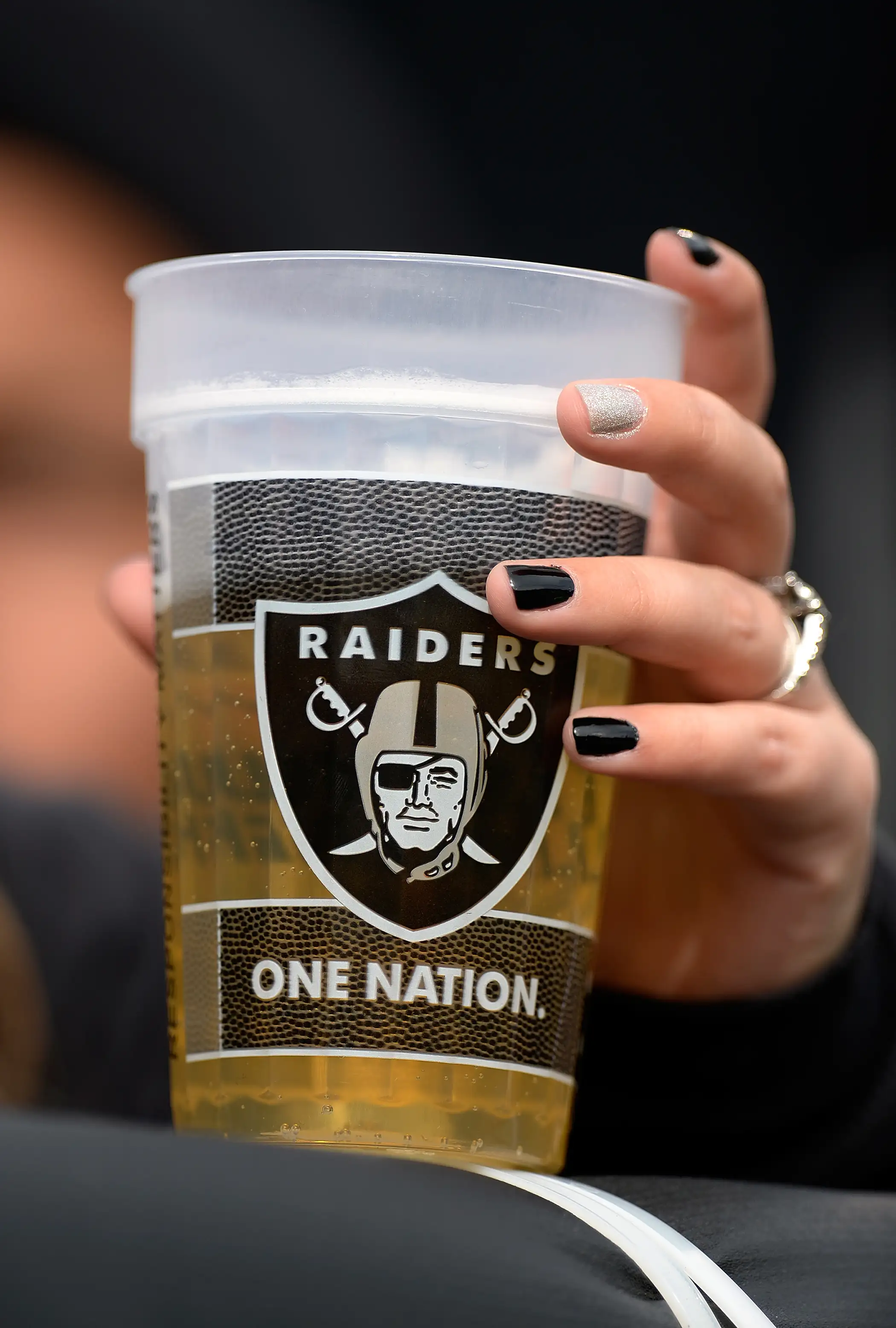 A fan holds onto her beer during an NFL Football game between the Philadelphia Eagles and the Oakland Raiders at O.co Coliseum on November 3, 2013 in Oakland, California.