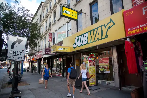 Pedestrians pass a Subway restaurant on Atlantic Avenue in Brooklyn, U.S., on Thursday, August 27, 2015.  Photographer: Michael Nagle/Bloomberg