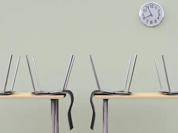 Chairs on desk under wall clock