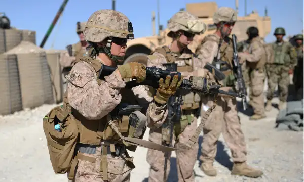 Members of Female Engagement Team (FET), US Marines GySgt Michelle Hill (L) and Cpl. Reagan Odhner (C) from the 1st battalion 7th Marines Regiment unload their M4 rifles after a patrol with Afghanistan National Army (ANA) soldiers in Sangin in Helmand Province on June 6, 2012.
