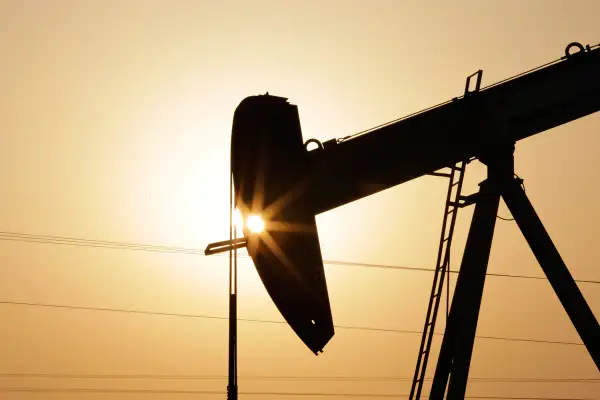 An oil pump works at sunset, September 30, 2015, in the desert oil fields of Sakhir, Bahrain.