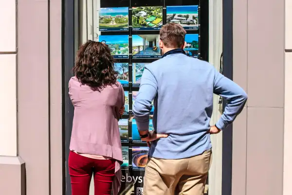A couple looks at a window display of homes for sale outside a real estate brokers office in Sarasota, Florida, February 21, 2015.