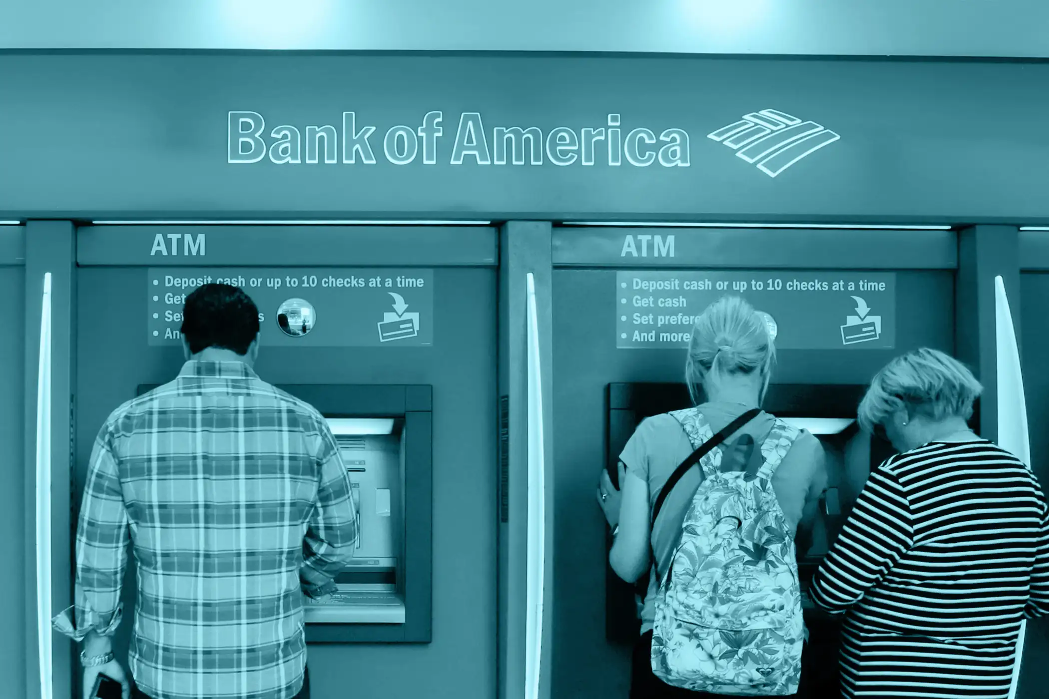 In this photo taken, July 13, 2015, customers use ATMs at a branch office of Bank of America in New York.
