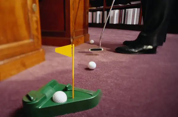 practicing putting golf in office