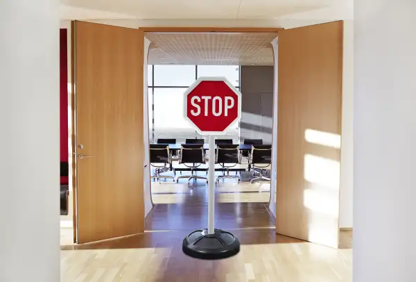 stop sign in front of the doors to a meeting room