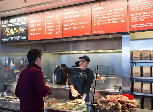 A Chipotle Mexican Grill employee prepares a burrito for a customer on December 15, 2015, in Seattle.