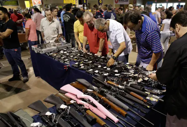 People shop for guns at a gun show hosted by Florida Gun Shows, January 9, 2016, in Miami. Schlesinger purchased an Uzi and a Smith & Wesson 38.