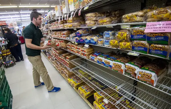 Bridgewater College junior communication major Jonah Barnhart, of Culpepper, Virginia, a floor stocker at Bridgewater Foods, races against shoppers stocking up before this weekend's snow storm to keep the bread aisle as full as possible for customers on January 20, 2015, in Bridgewater, Virginia. Heavy snowfall that's predicted to arrive by the weekend from Appalachia to Philadelphia and maybe farther north.