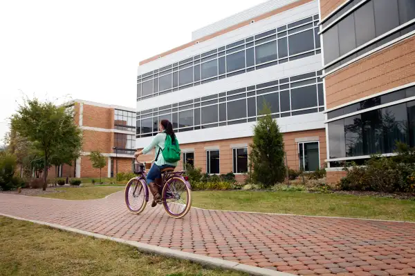 girl riding bicycle on campus