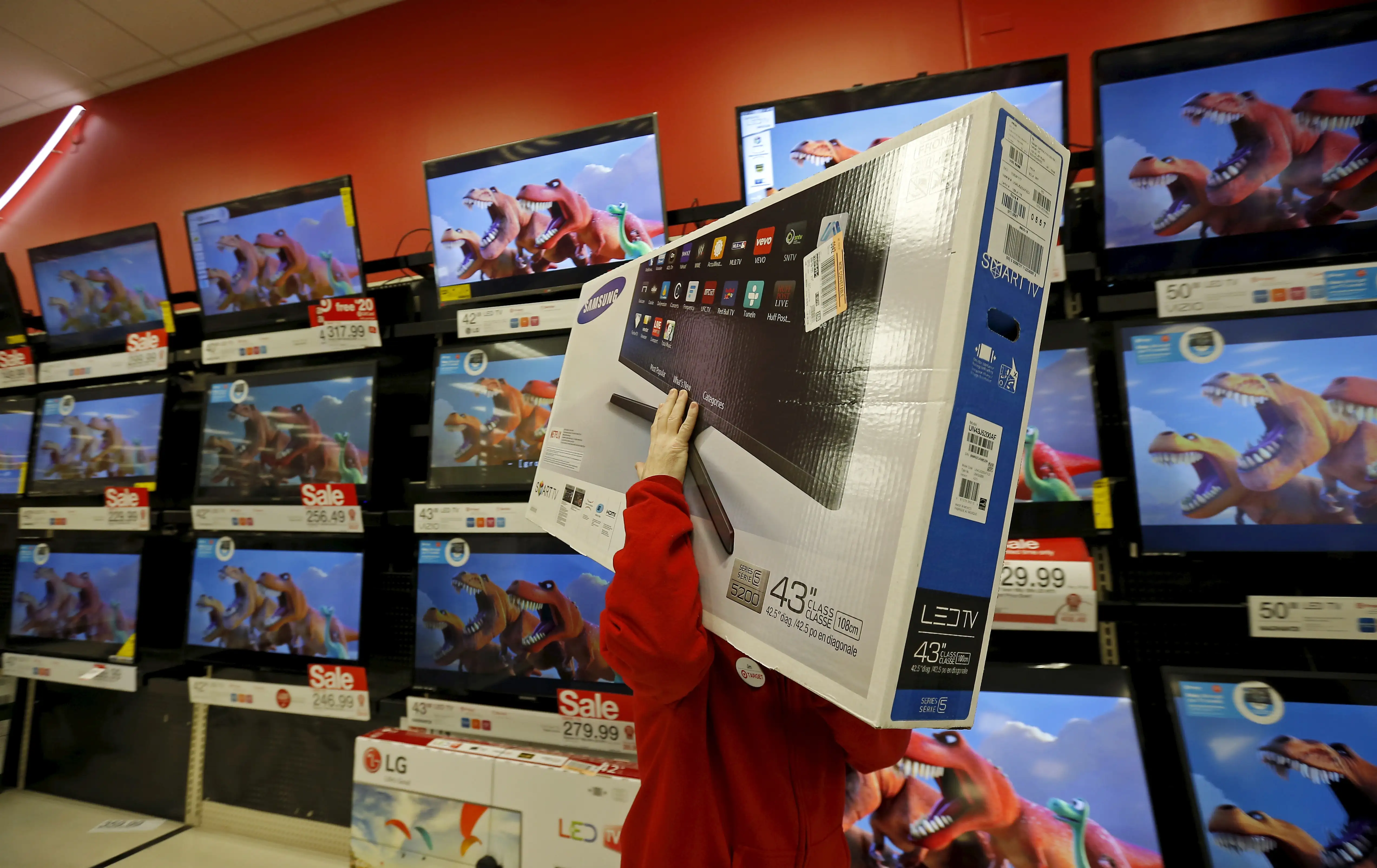 A worker carries a television for a customer who made a purchase during Black Friday Shopping at a Target store in Chicago, Illinois, November 27, 2015.