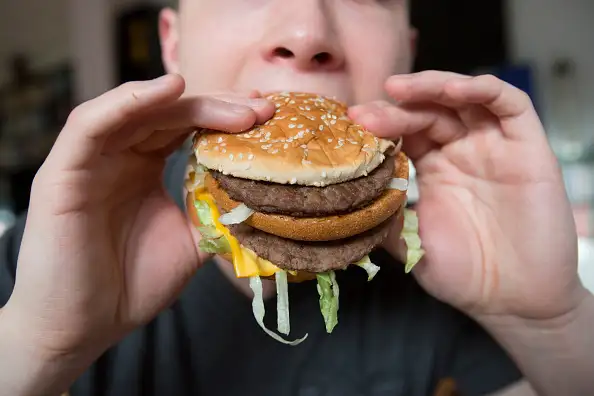 Fast Food - hands hold a burger.