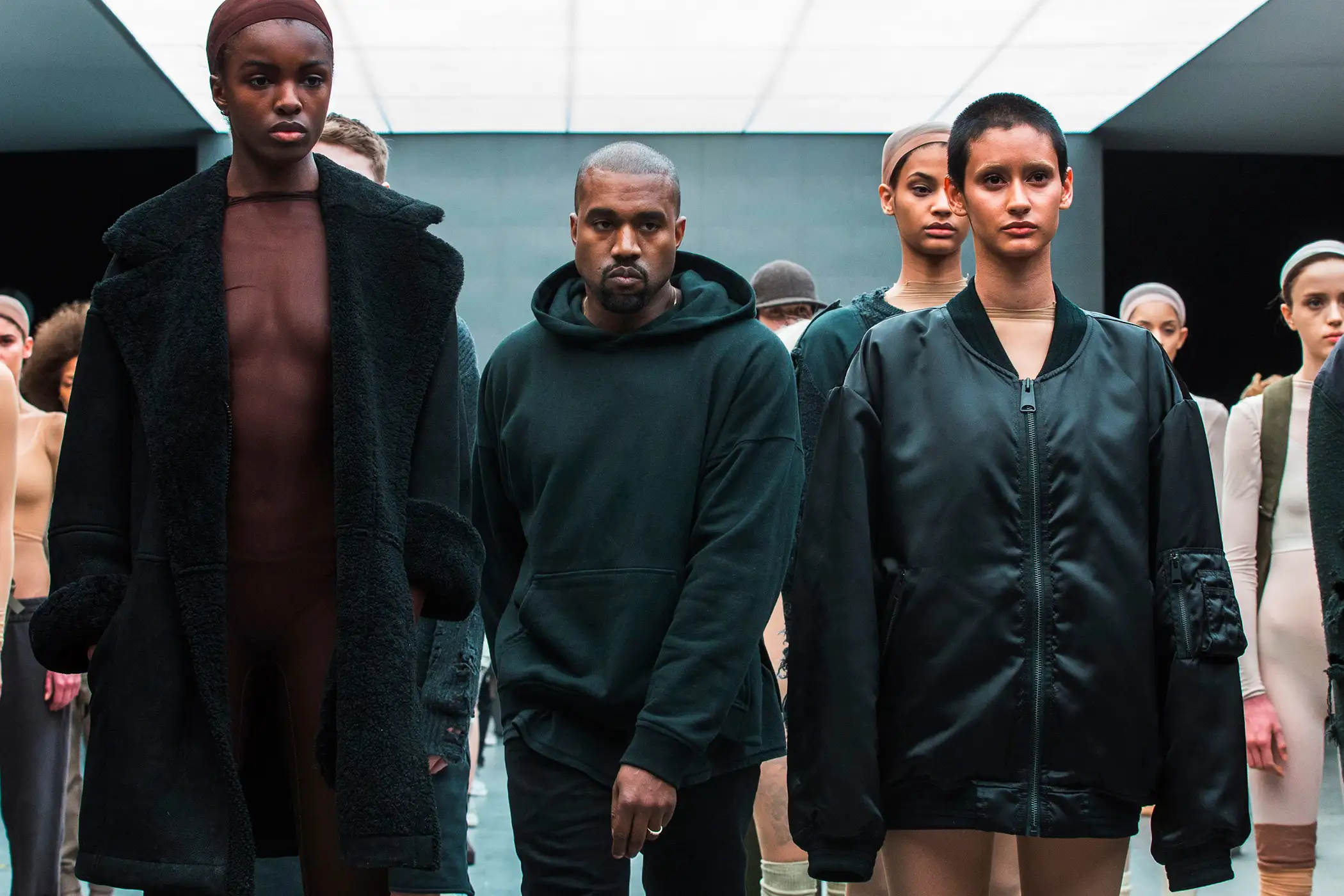 Singer Kanye West walks past models after presenting his Fall/Winter 2015 partnership line with Adidas at New York Fashion Week February 12, 2015.