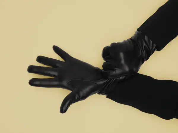 Mature woman adjusting leather gloves, close-up of hands