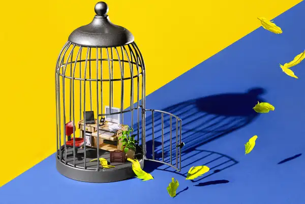 birdcage with miniature office inside, feathers flying