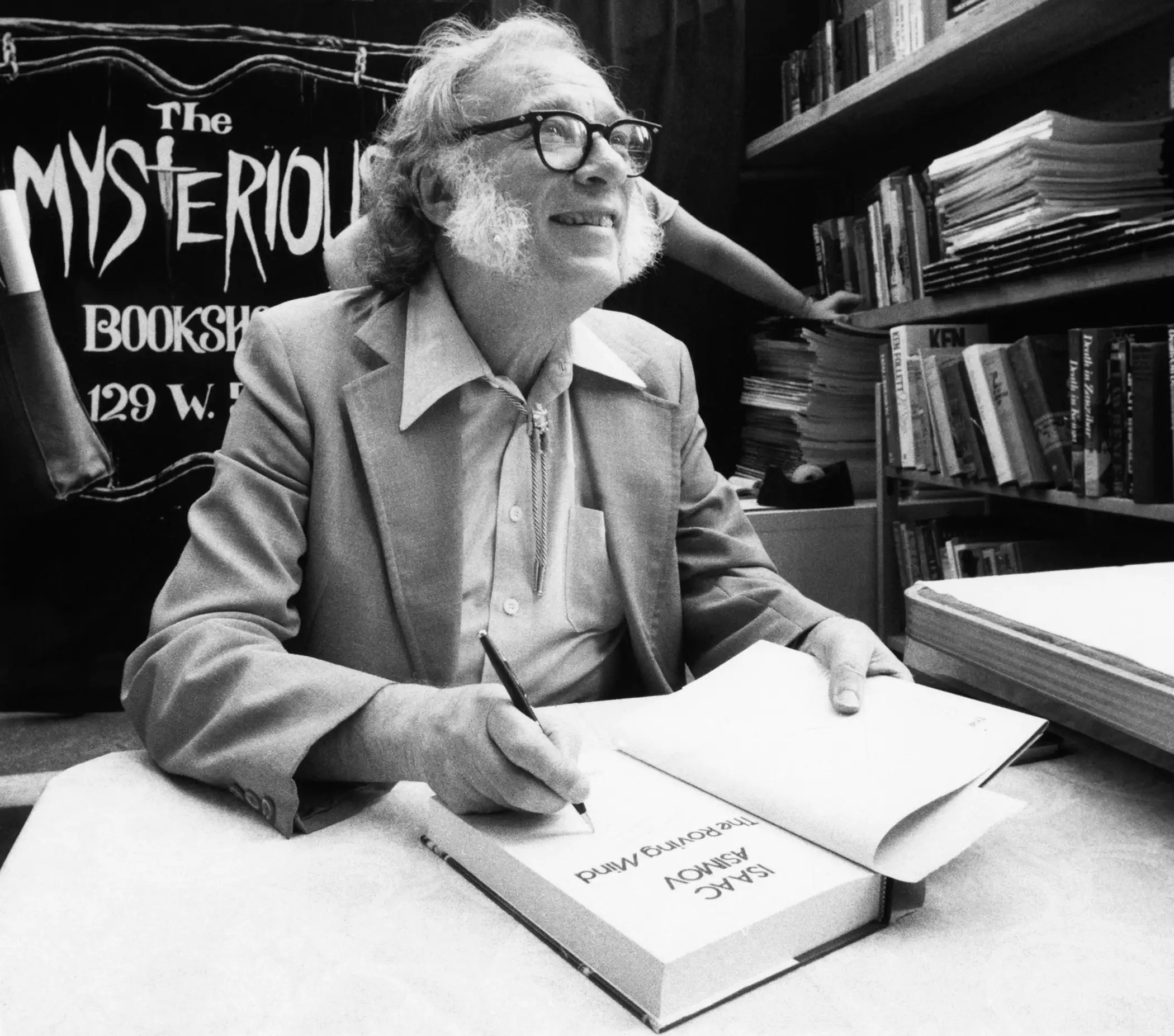 Author Isaac Asimov autographs books at the Mysterious Book Store stall on February 2, 1984 during the Fifth Avenue Book Fair held in New York City, United States.
