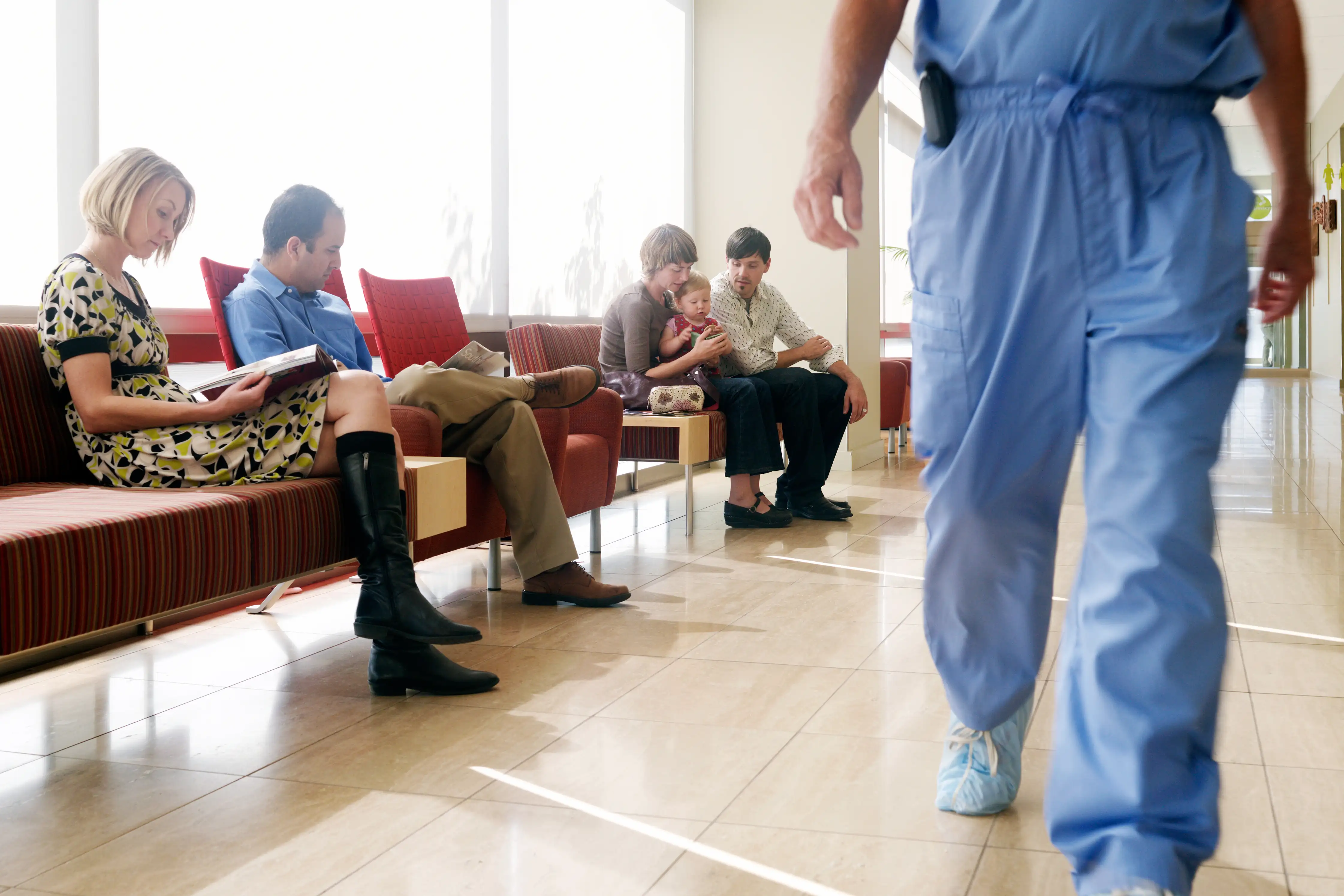 patients waiting with doctor walking past