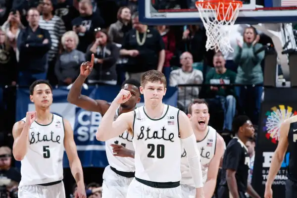The Michigan State Spartans celebrate after defeating the Purdue Boilermakers in the championship game of the Big Ten Basketball Tournament at Bankers Life Fieldhouse on March 13, 2016 in Indianapolis, Indiana. Michigan State defeated Purdue 66-62.