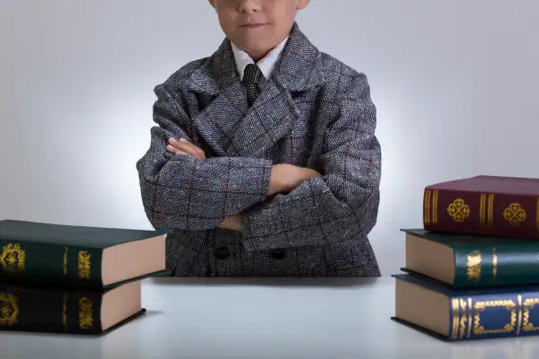 little boy dressed in suit with encyclopedias