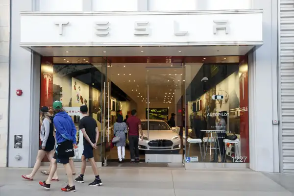 Pedestrians walk past the Tesla Motors Inc. showroom at the Third Street Promenade in Santa Monica, California, on March 22, 2016.