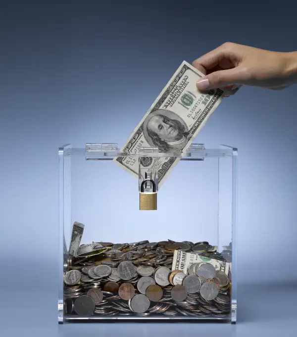 woman dropping money in charity donation box