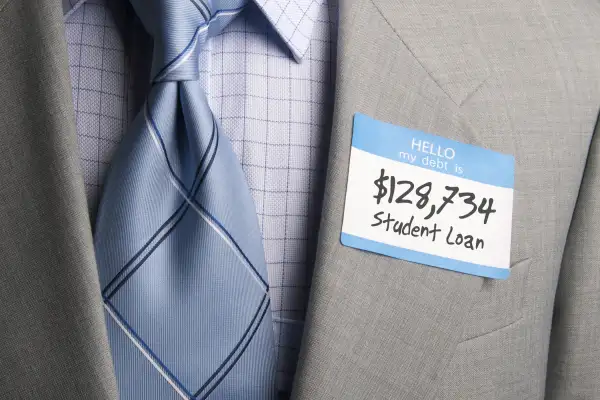 man in suit wearing  hello my debt is....$128,734 Student Loan  sticker