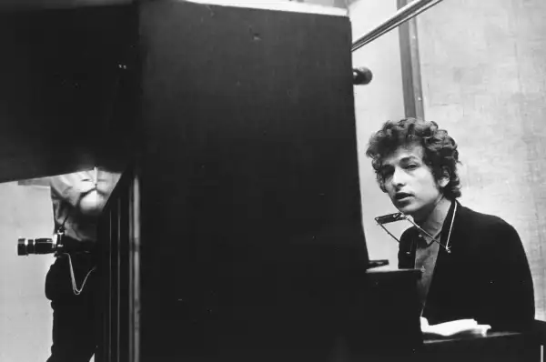 Bob Dylan (seated at the piano with a harmonica around his neck) takes a break during the recording of the album 'Highway 61 Revisited' in Columbia's Studio A in the summer of 1965 in New York City, New York.