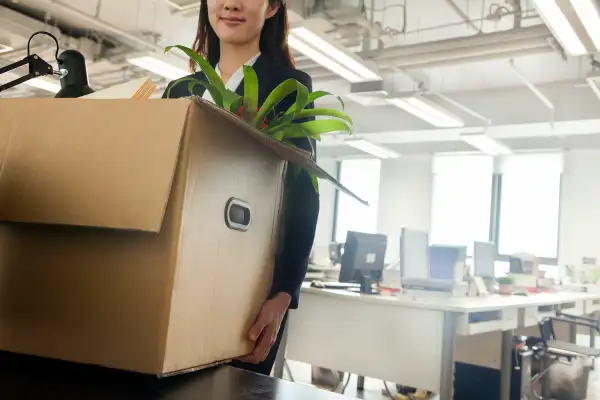 woman carrying box out of office