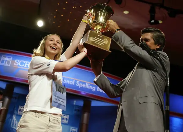 Katharine Close, 13, of Spring Lake, New Jersey, gets a hand from EW Scripps Company CEO Ken Lowe while holding up the championship trophy after winning the 2006 Scripps National Spelling Bee June 1, 2006 in Washington, DC. Katharine won after spelling the word  Ursprache.  She is the first female winner of the bee since 1999.