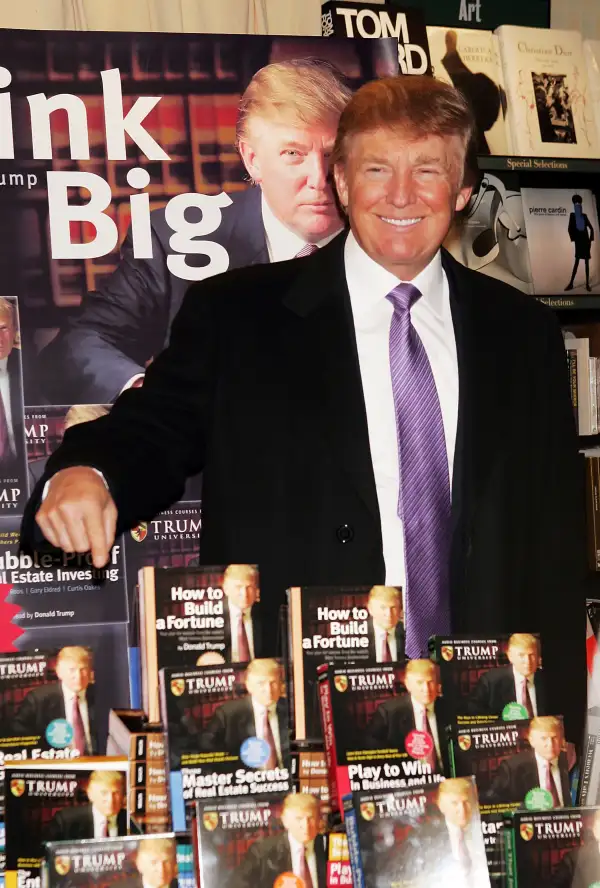 Donald Trump gestures as he poses for a photo during an in-store appearance to sign copies of  How To Build Wealth,  which is a series of nine audio business courses created by Trump University, at a Barnes & Noble store January 10, 2005 in New York City.