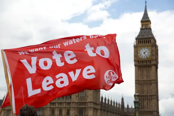 Leave supporters hold flags as they stand on Westminster Bridge during an EU referendum campaign stunt in which a flotilla of boats supporting  Leave  sailed up the River Thames outside the Houses of Parliament in London, Wednesday, June 15, 2016. A flotilla of boats protesting EU fishing polices has sailed up the River Thames to the Houses of Parliament as part of a campaign backing Britain's exit from the European Union. The flotilla was greeted by boats carrying  remain  supporters.