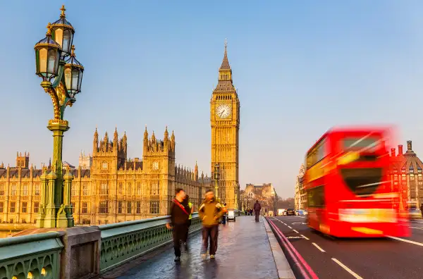 Red double-decker bus passing Big Ben, London