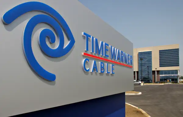 A Time Warner Cable logo appears on a sign outside the compa